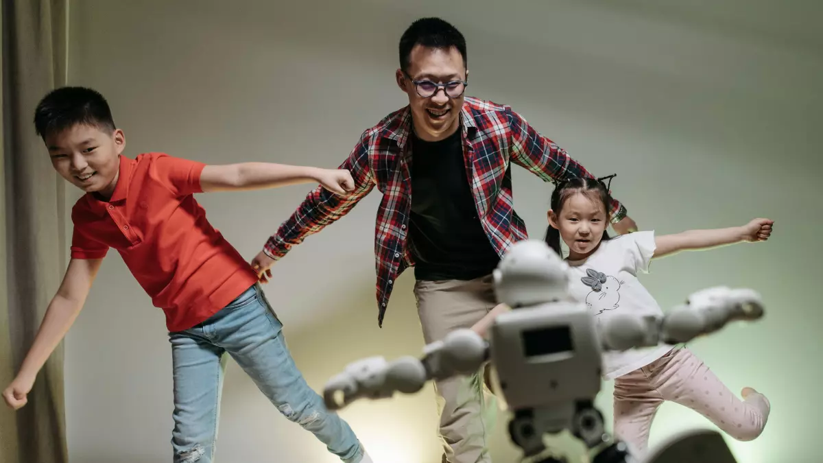 A humanoid robot is shown interacting with a family. The robot is standing on a white rug in a living room with a family of three. The family is interacting with the robot and it looks like they are having fun.