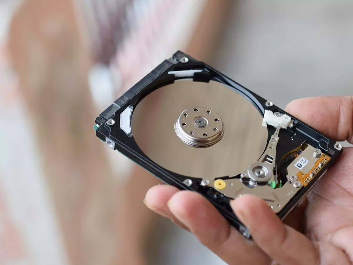 A person is holding a hard drive in their hand. 