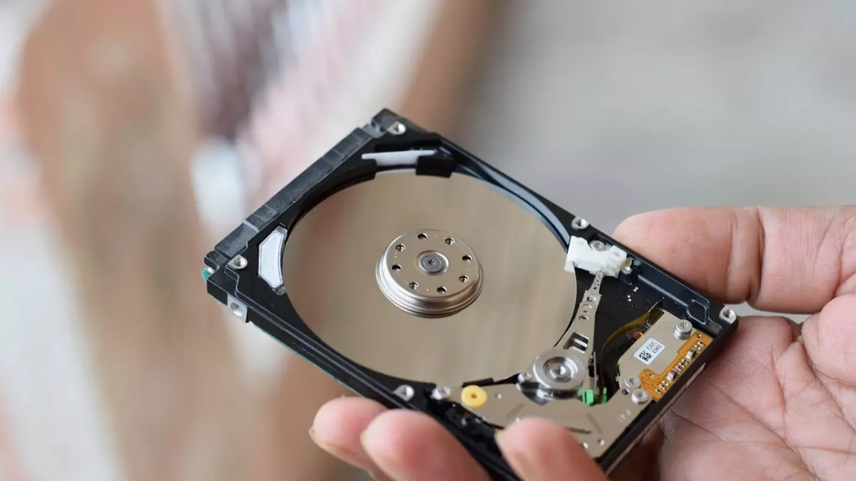 A person is holding a hard drive in their hand. 