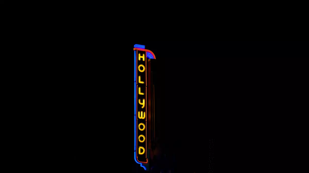 A close-up shot of the Hollywood sign at night, with vibrant neon lighting.