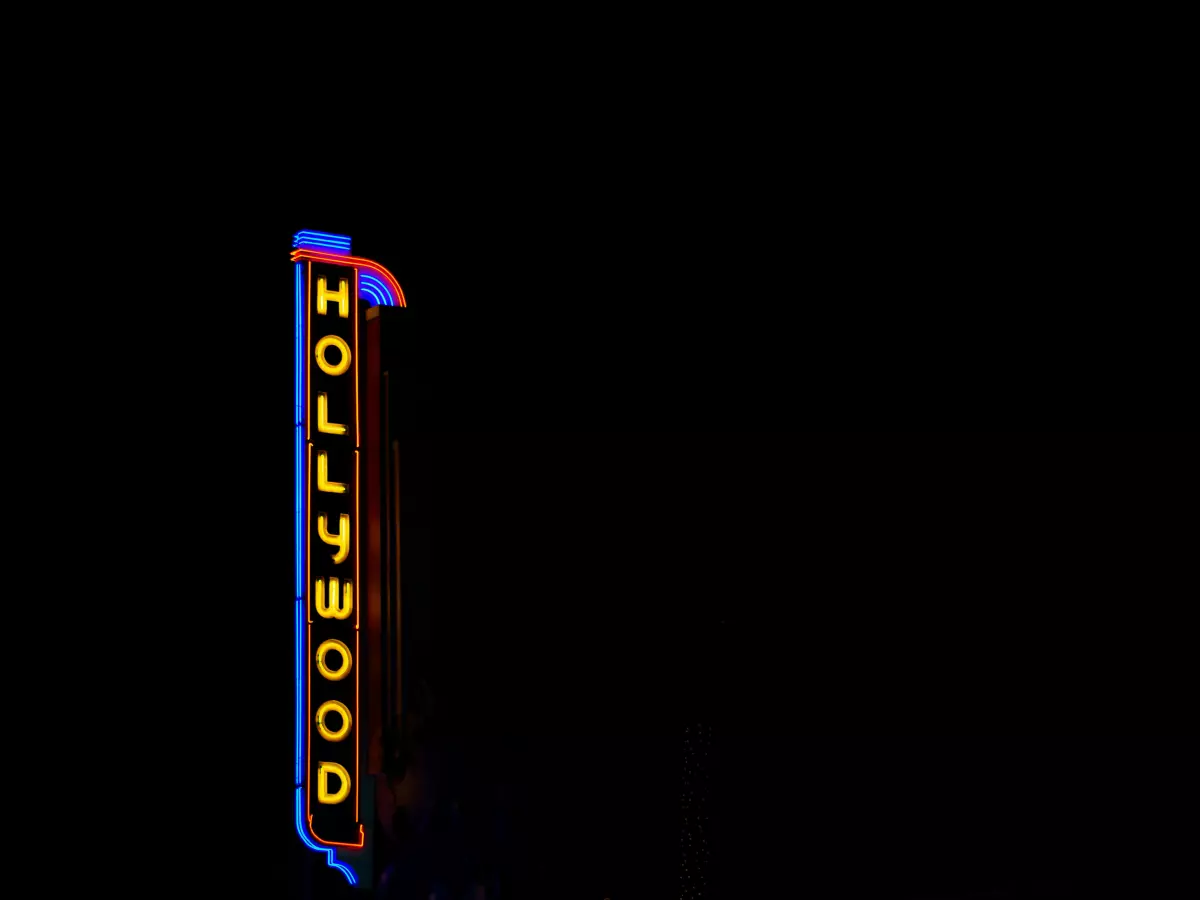 A close-up shot of the Hollywood sign at night, with vibrant neon lighting.