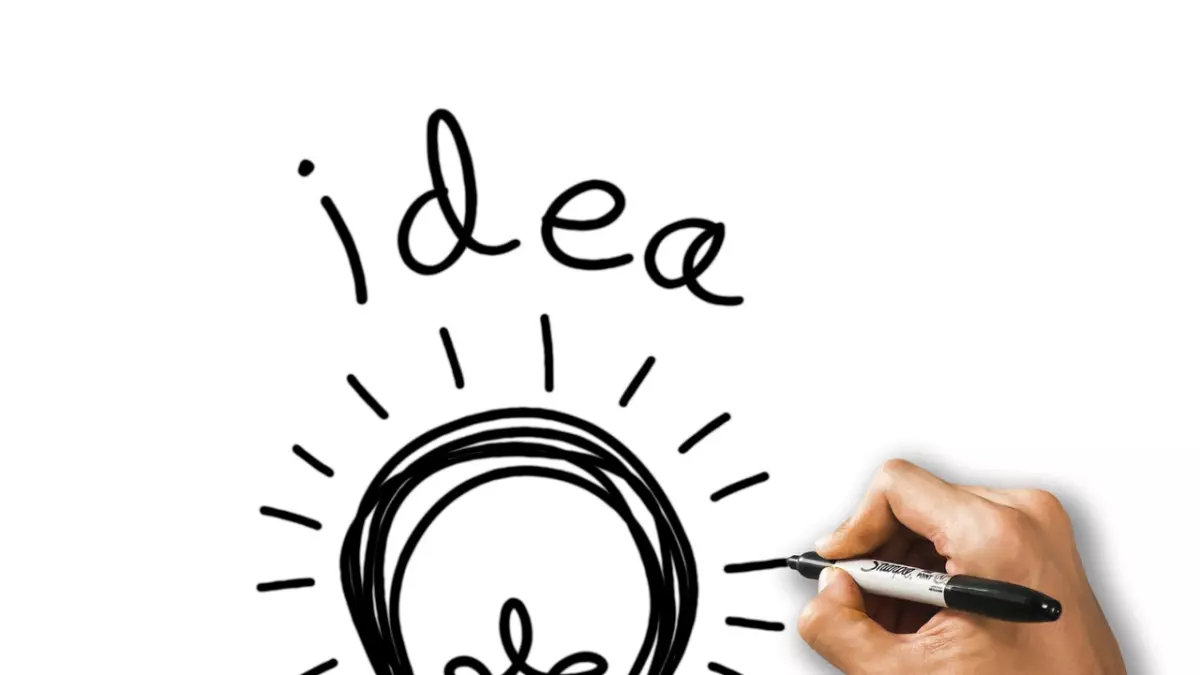 A hand drawing a lightbulb on a white board, representing ideas and innovation.