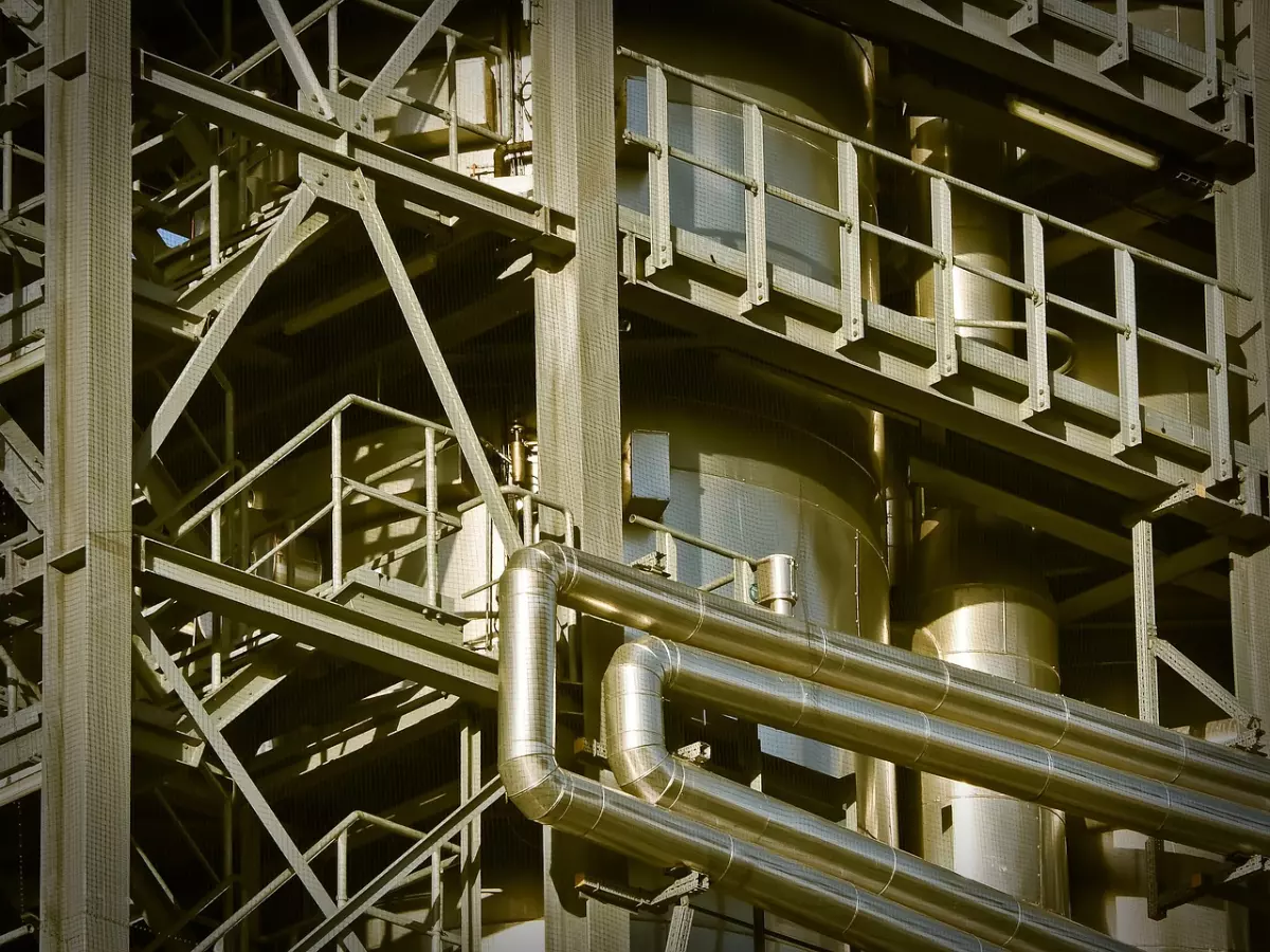 Close-up shot of a factory with large pipes and metal structures.