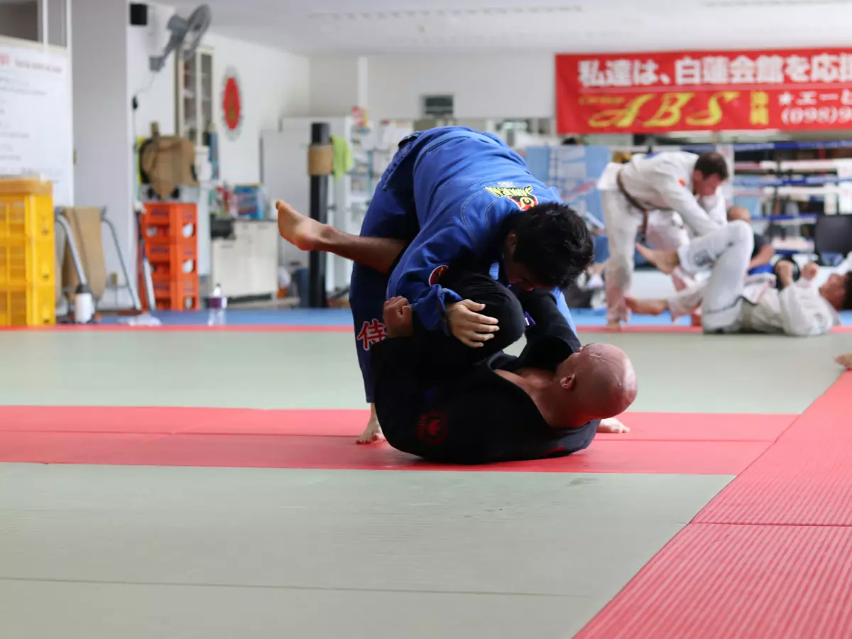 Two men grappling in a martial arts class.