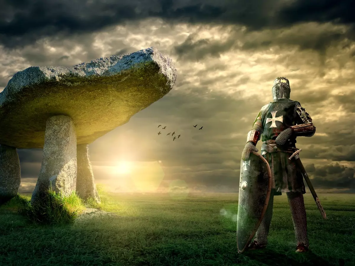 A dramatic picture of a knight in armor standing guard in front of a stone monument. The sky is cloudy and dark, and the light is coming from the sun behind the knight.