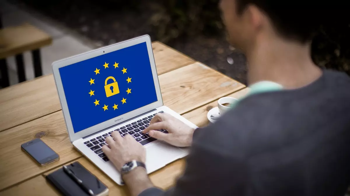 A person working on a laptop with the EU flag and a padlock on the screen.