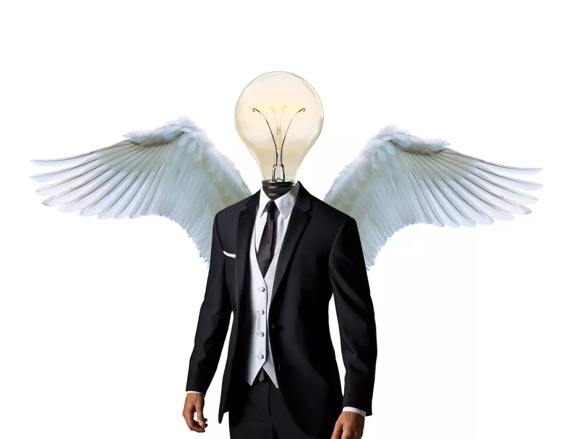 A man in a suit is standing with a light bulb for a head and angel wings. He is looking to the right.