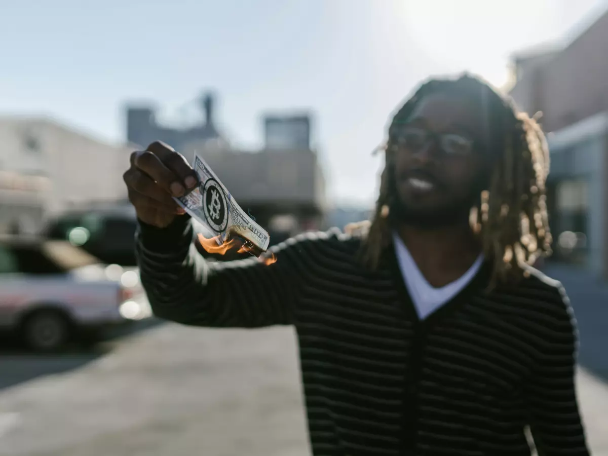 A man with dreadlocks smiling while holding something in his hand.