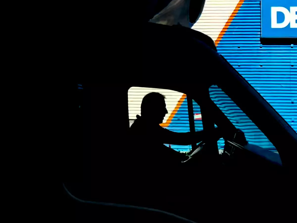 A silhouette of a man driving a car. The word 'DECA' is visible in the background.