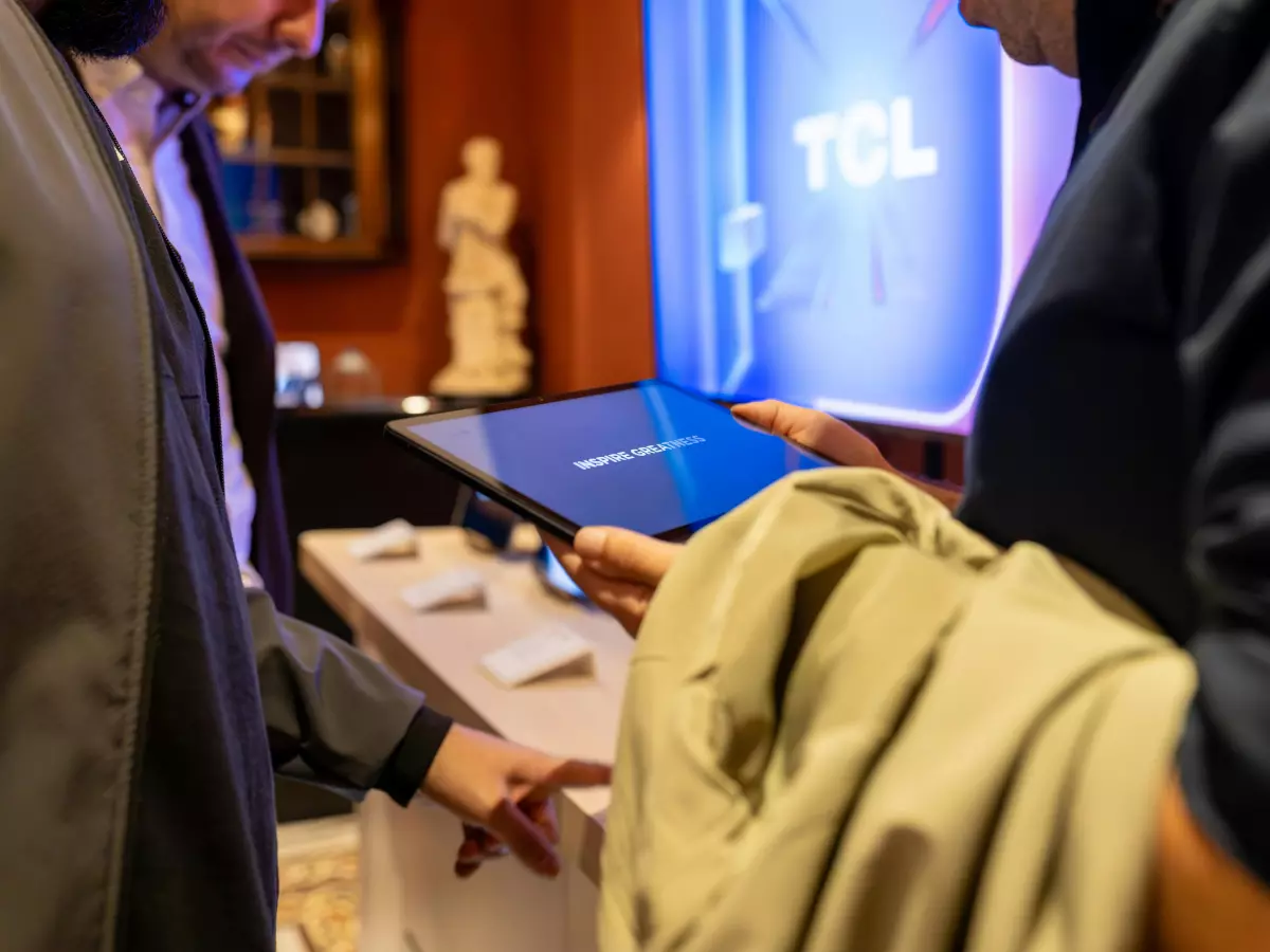 A person interacting with a TCL NXTFrame television displayed in a retail setting.