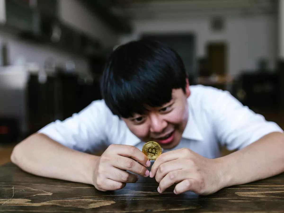 A man biting into a Bitcoin coin.