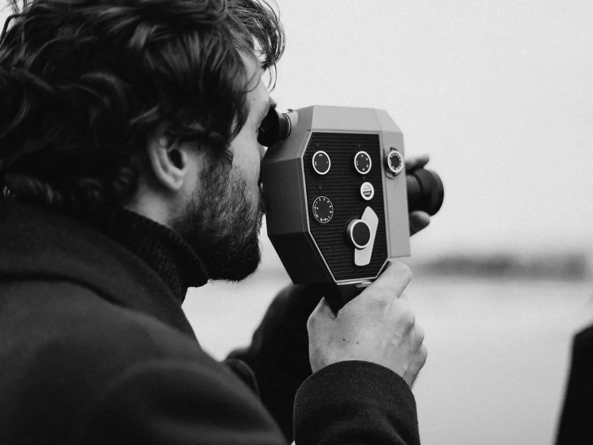 A person filming with a vintage camera