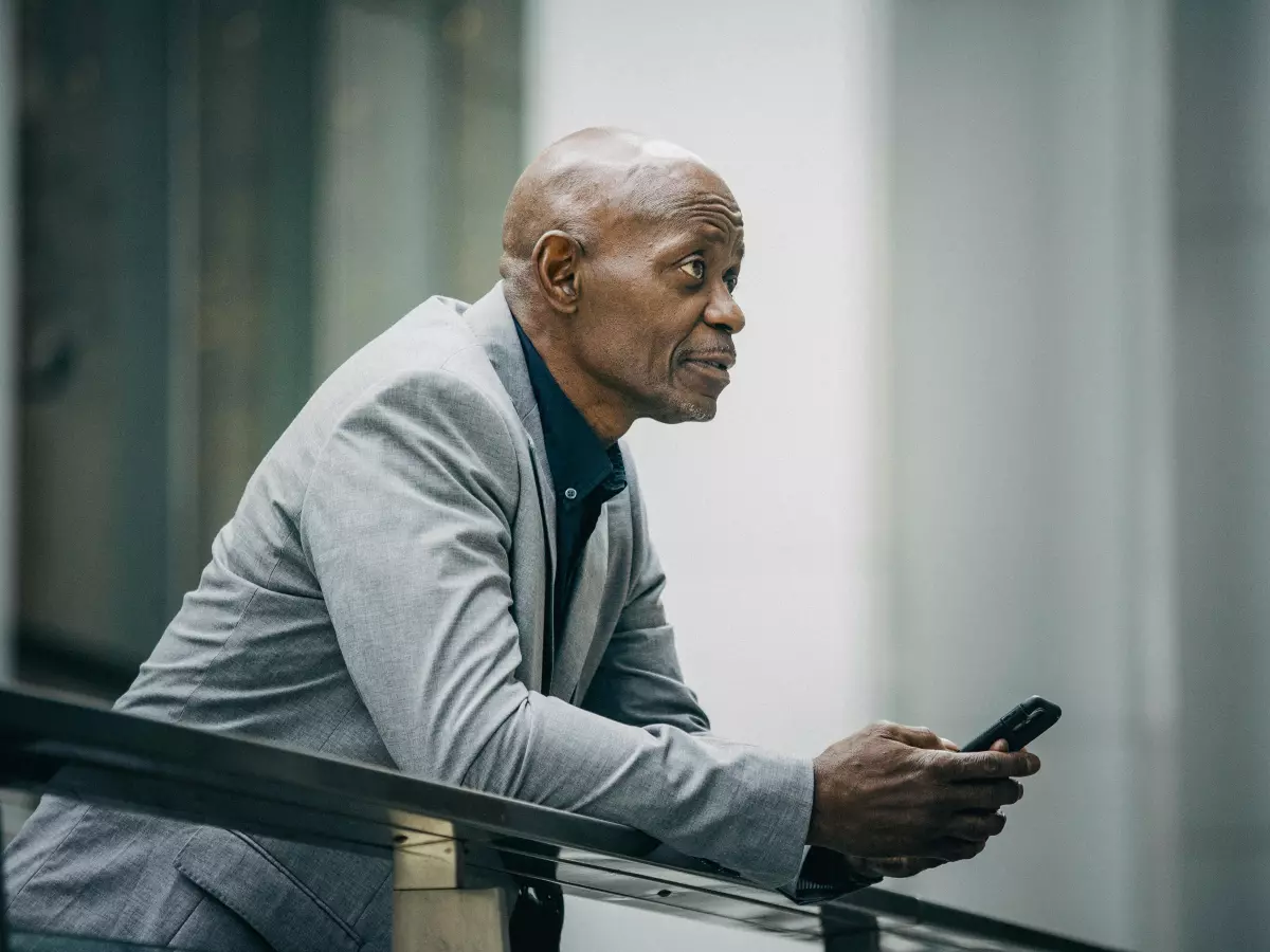 A man in a suit uses his smartphone.