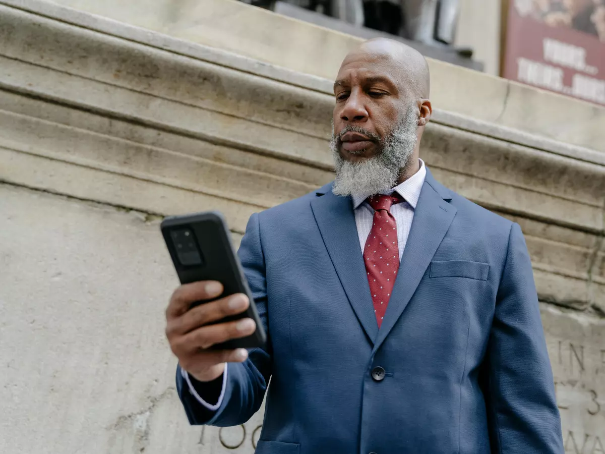 A man in a suit is looking at his phone.