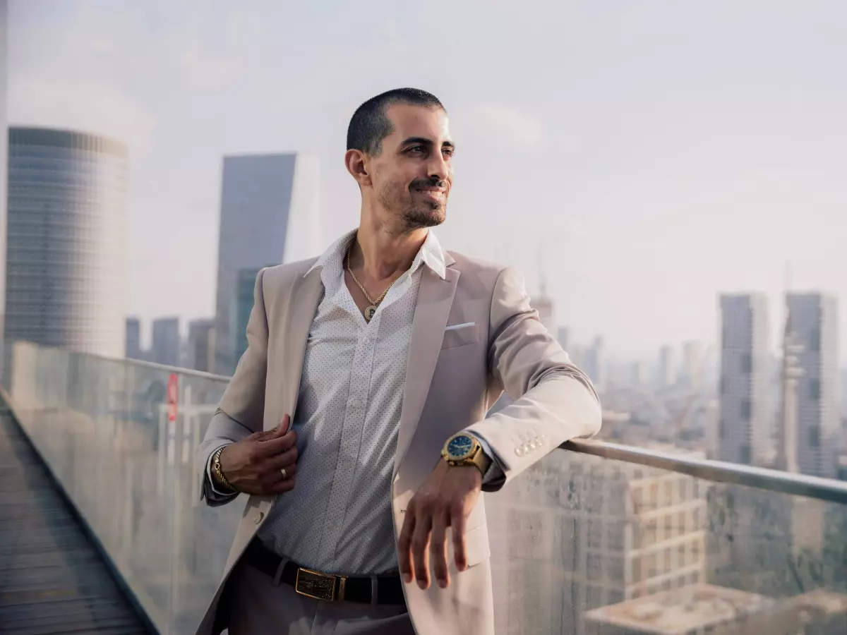 A man in a suit standing on a rooftop overlooking a city skyline.