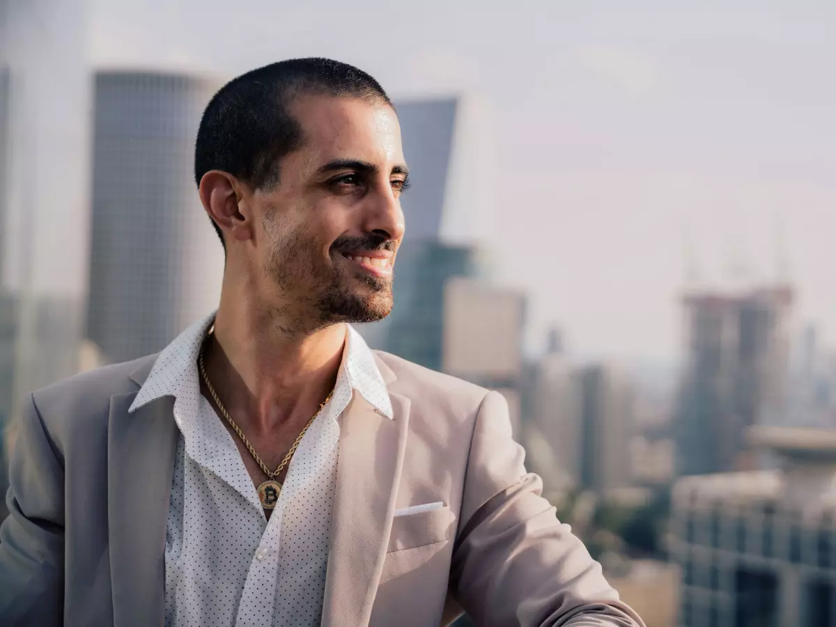 A man in a suit standing on a rooftop looking out at the city skyline.