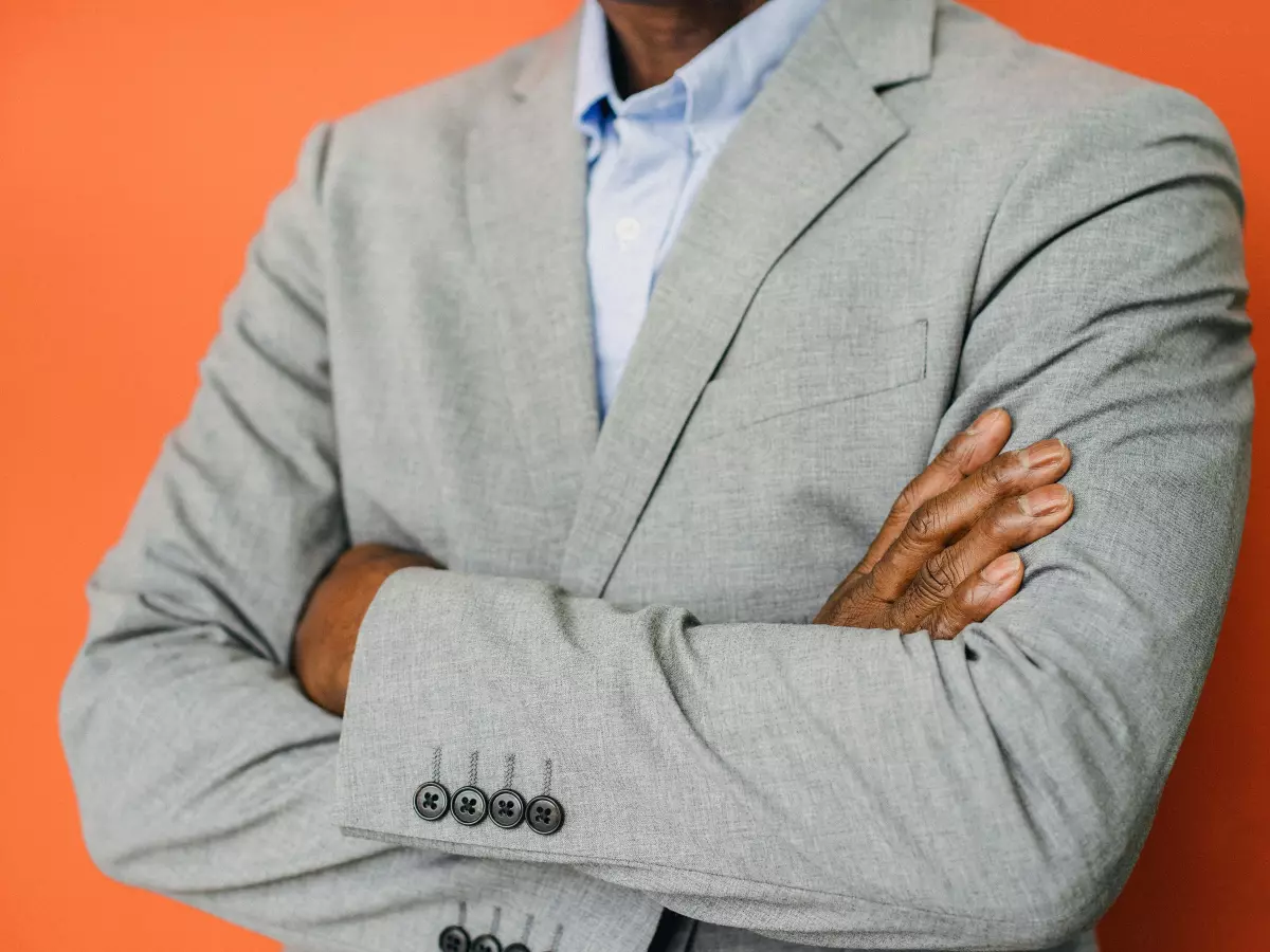 A confident businessman in a gray suit with a serious expression.