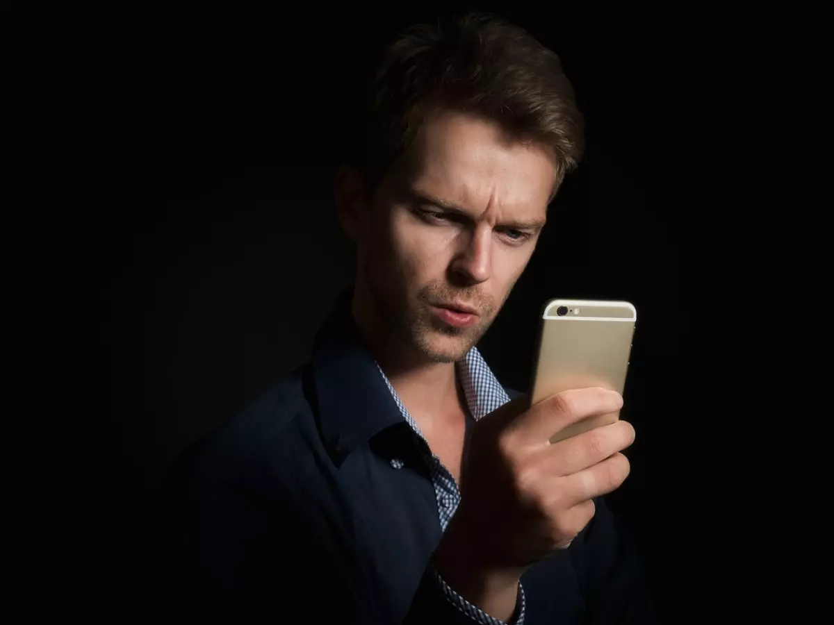 A person holding a smartphone with a map displayed on the screen, with a blurred background showing a global map.