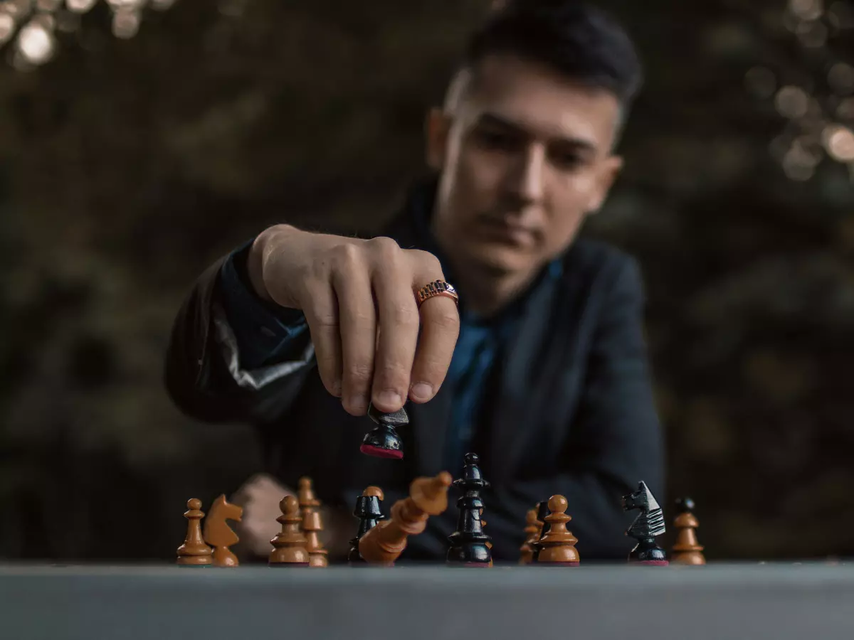 A man playing chess in a park.