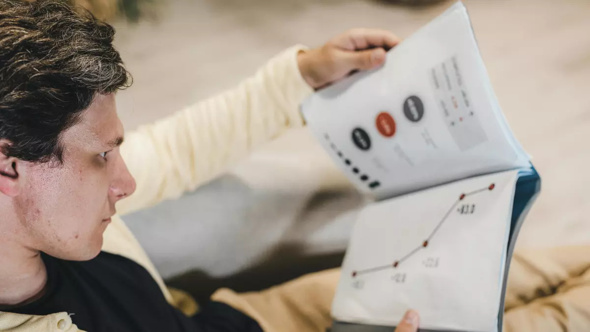 A man is looking at a data chart in a book.