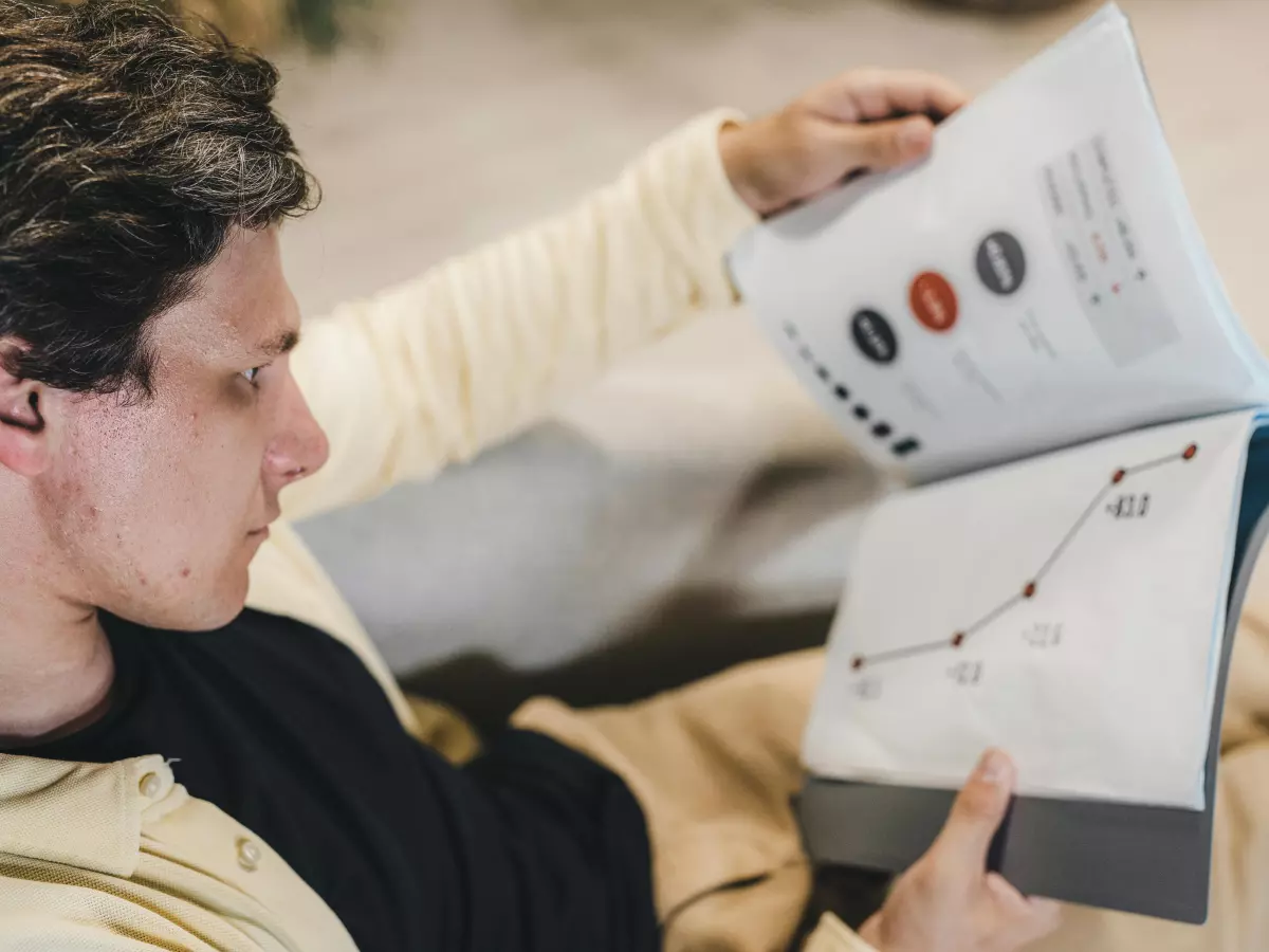 A man is looking at a data chart in a book.