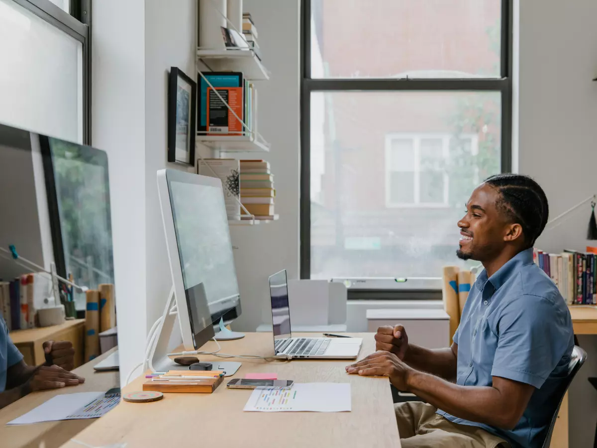 A man sits at a desk in front of a computer, working.