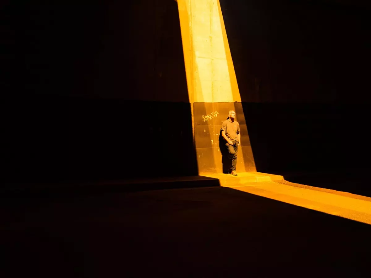 A person stands in a narrow beam of light