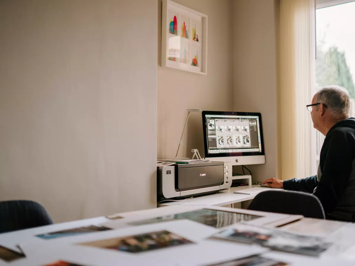 A person sitting in front of a computer editing photos.