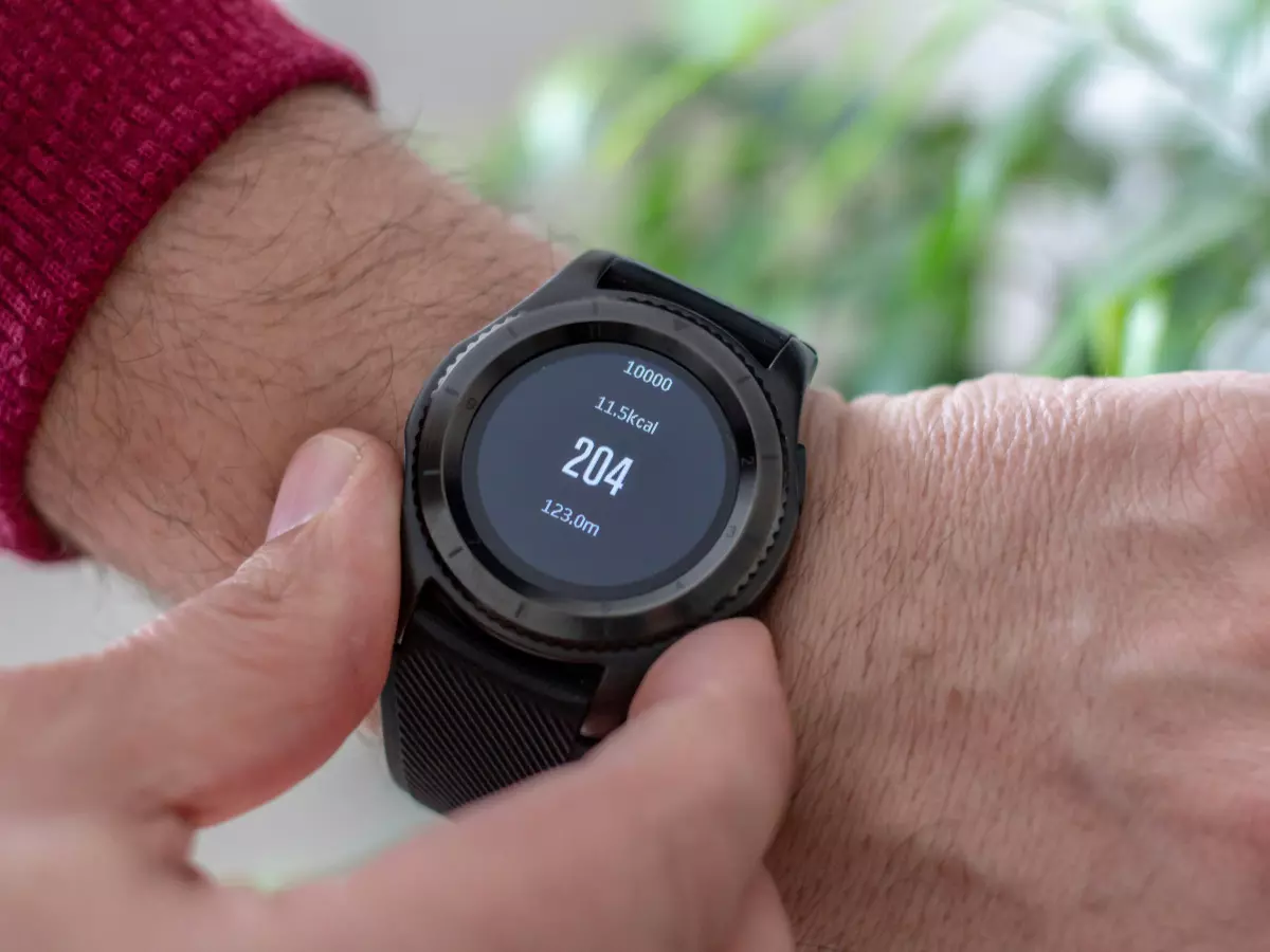 A man wearing a black Huawei Watch D2 with blood pressure reading on the screen