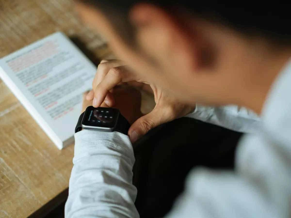 A person wearing a black Apple Watch Ultra 2 on their wrist. The watch is visible in the foreground, and the person's hand is visible in the background.