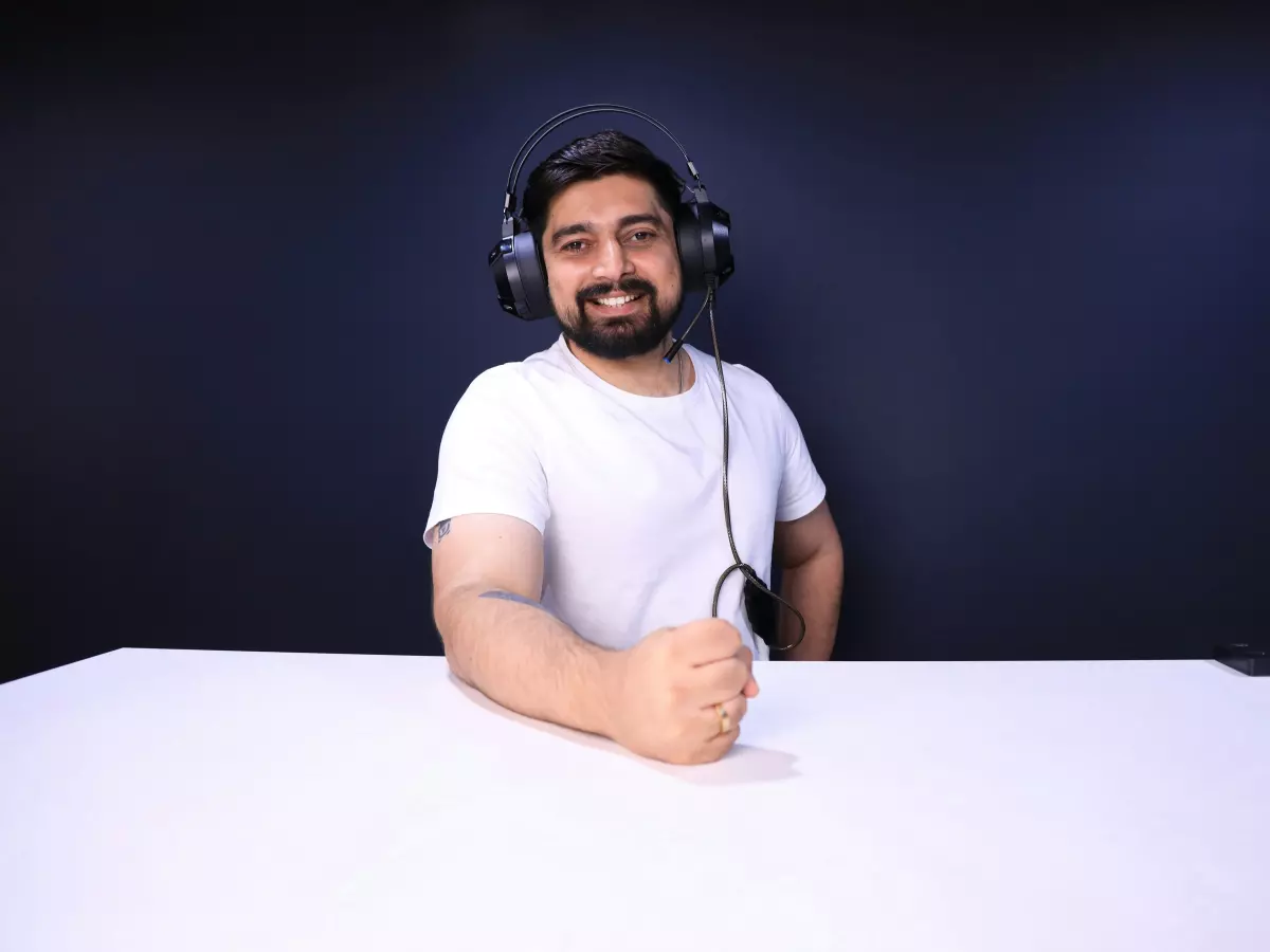 A young man wearing a headset sits at a desk with a serious expression on his face. He's ready for gaming.