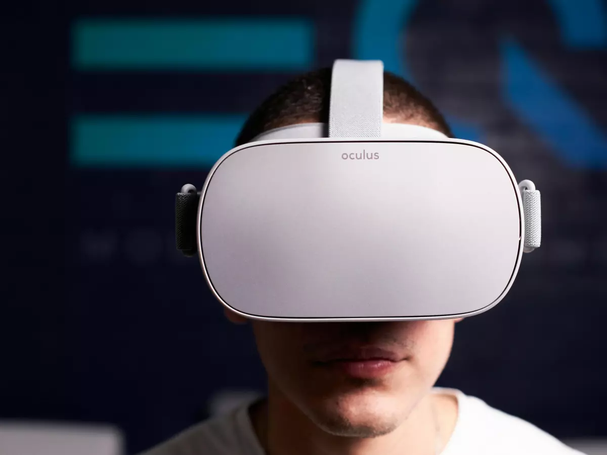 A man wearing a white VR headset. The headset is covering his face and he is looking directly at the camera.