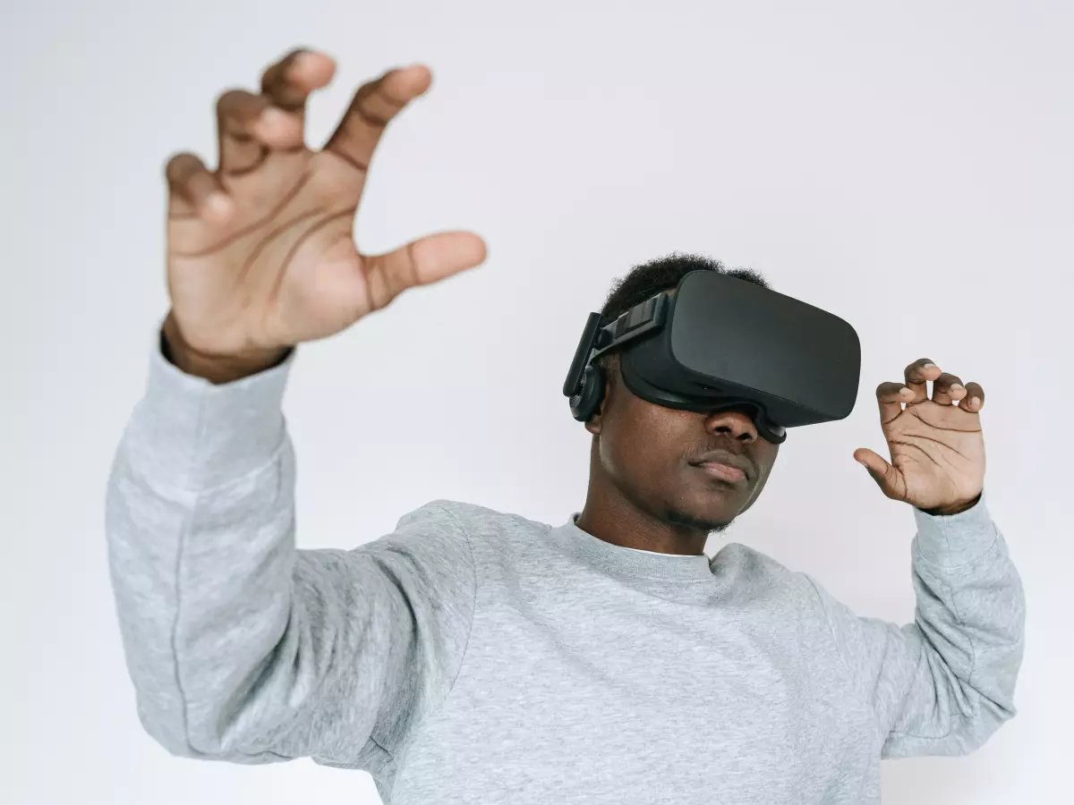 A man wearing a VR headset reaches out with his hands, as if interacting with something in the virtual world.