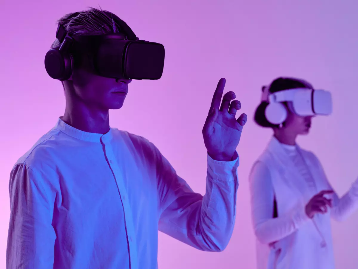 A couple wearing VR headsets interacting with each other in a futuristic setting.