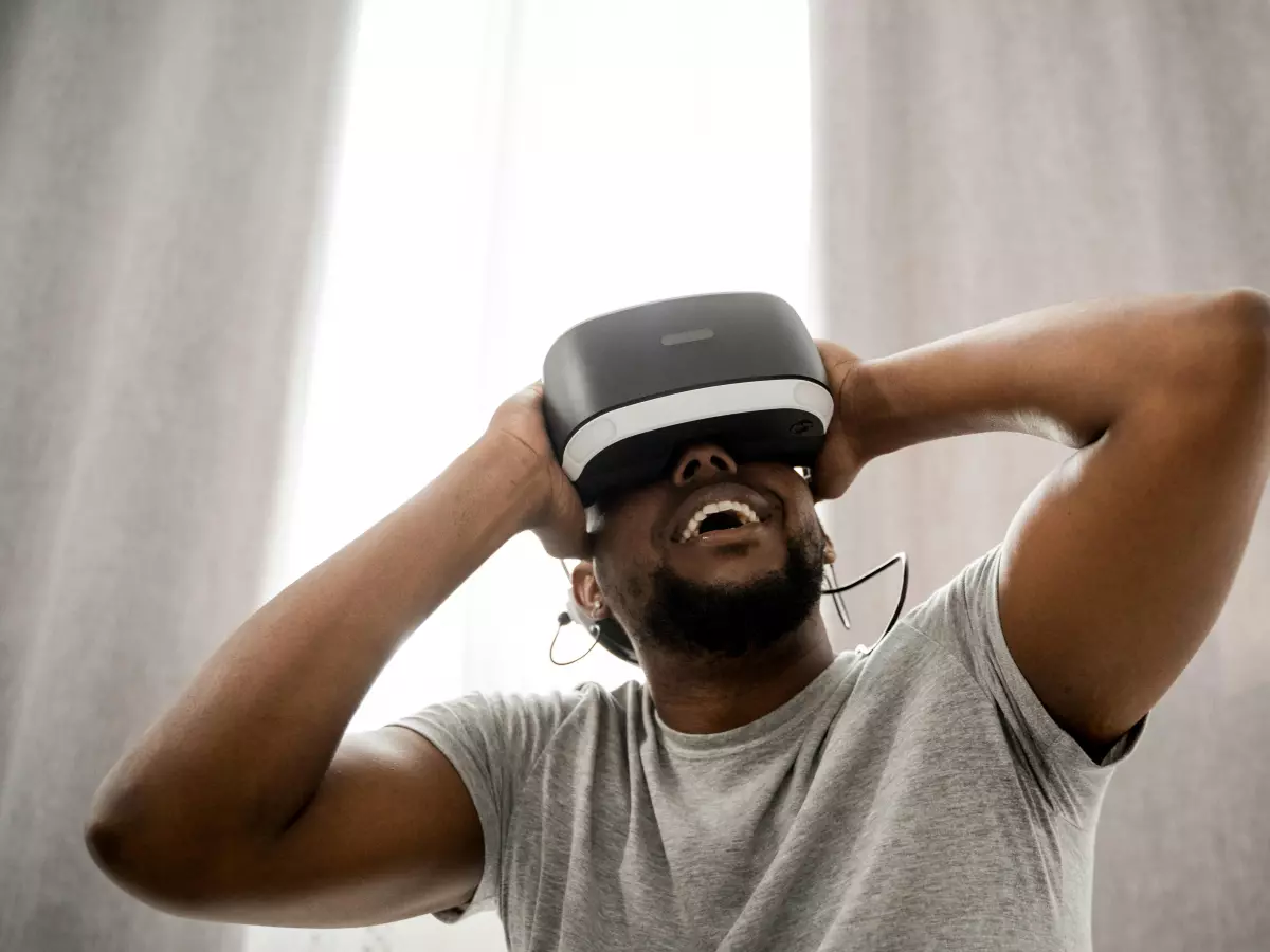 A man wearing a VR headset looks surprised and possibly overwhelmed by the experience.