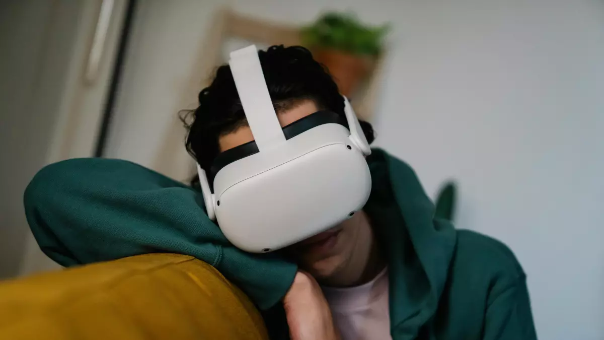 A person wearing a VR headset sits on a couch, with a focus on the headset.