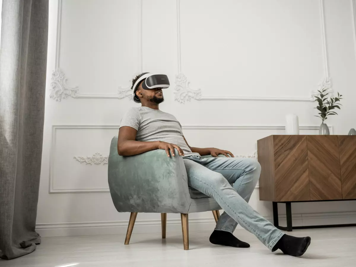 A man is sitting in a chair wearing a VR headset.