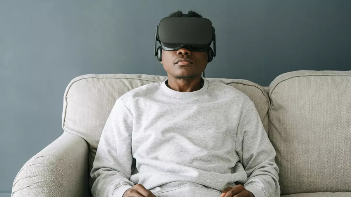 A person wearing a VR headset sits on a couch.