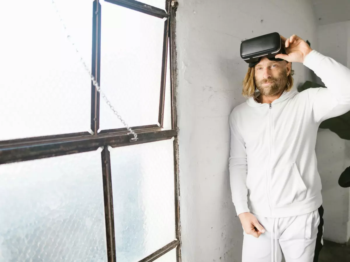 A man wearing a VR headset, standing in a room with a window.