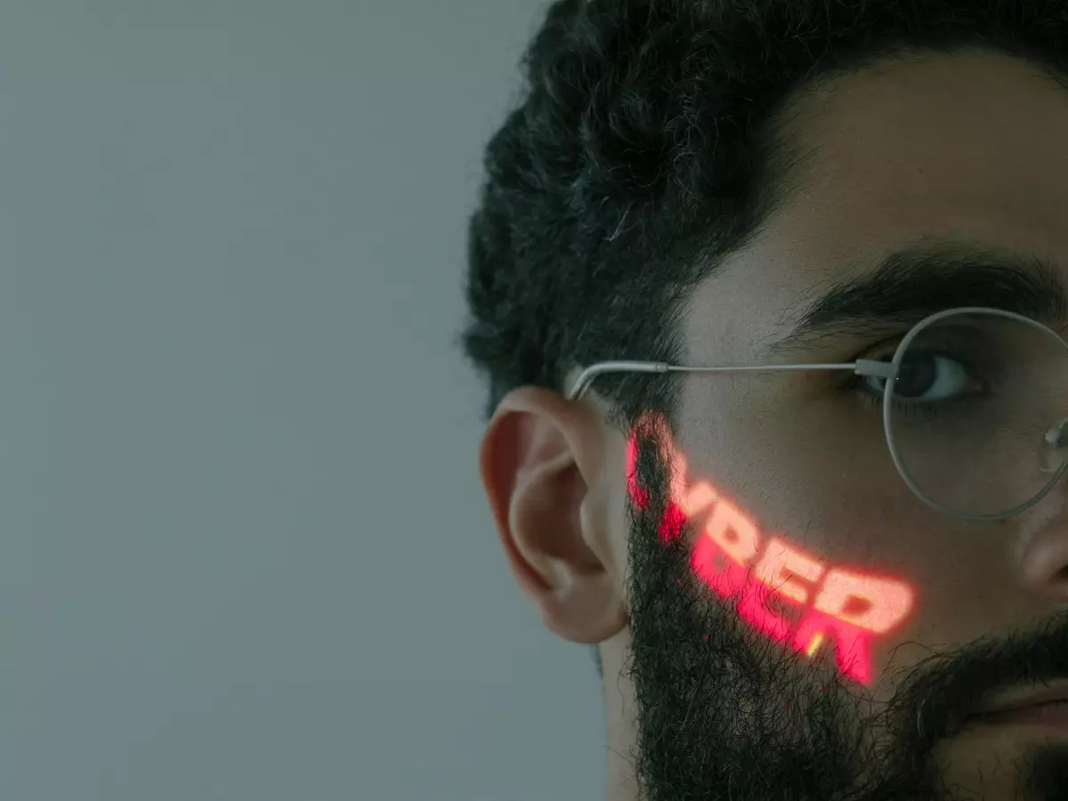 Close-up portrait of a man with a beard, wearing glasses. The word 'VIBER' is displayed on his cheek in a red glow.