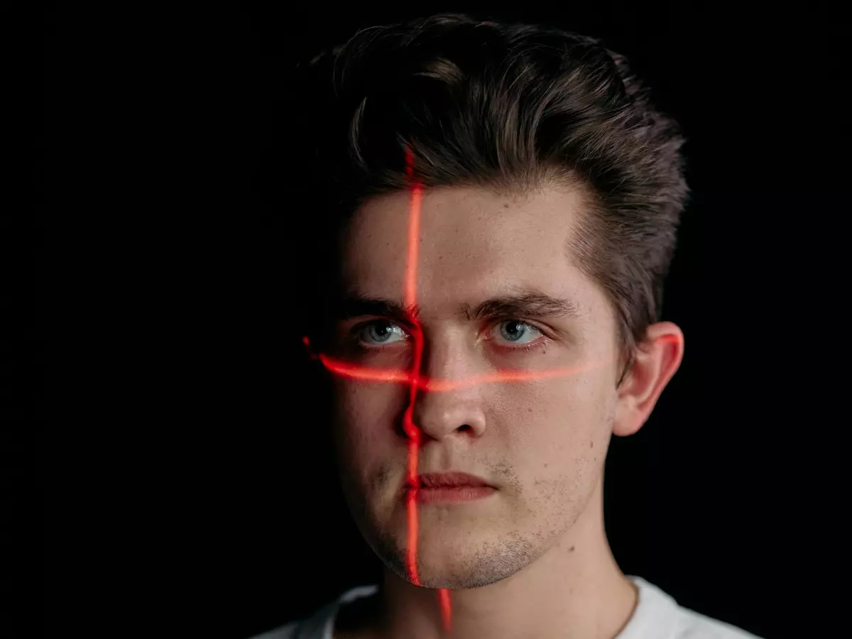 A man's face with a red laser grid on it.