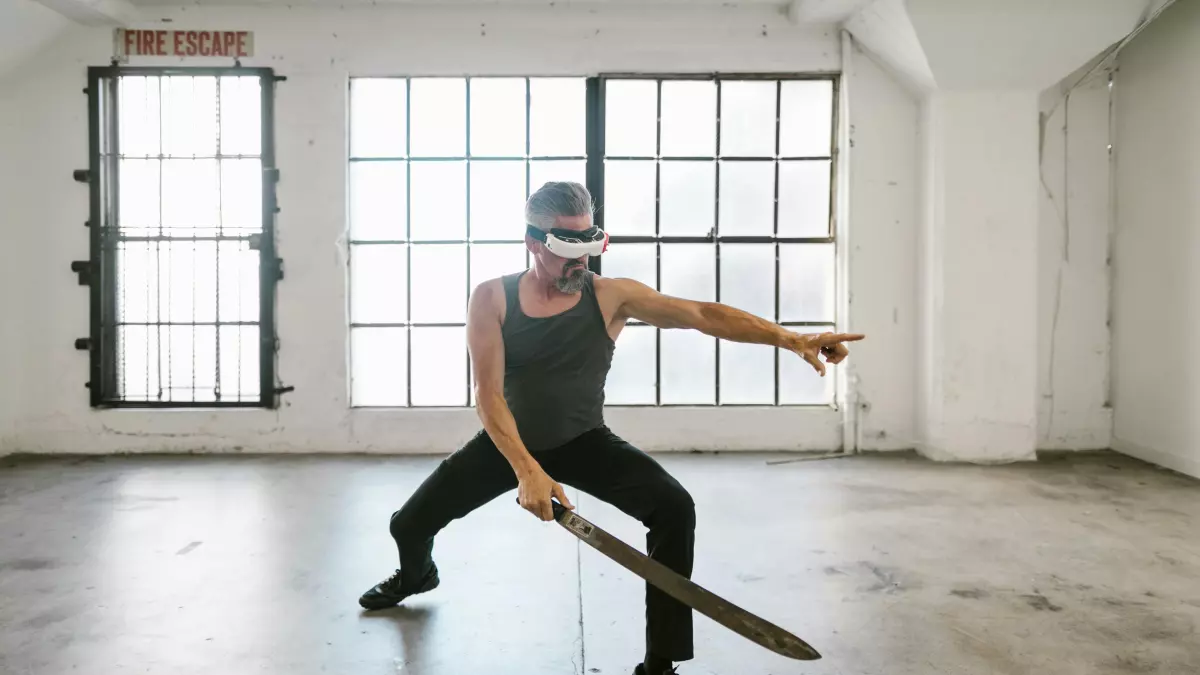 A person wearing a VR headset and holding a sword is performing a fighting pose.