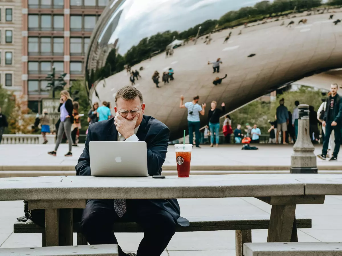 A businessman working on his laptop outside in a public space