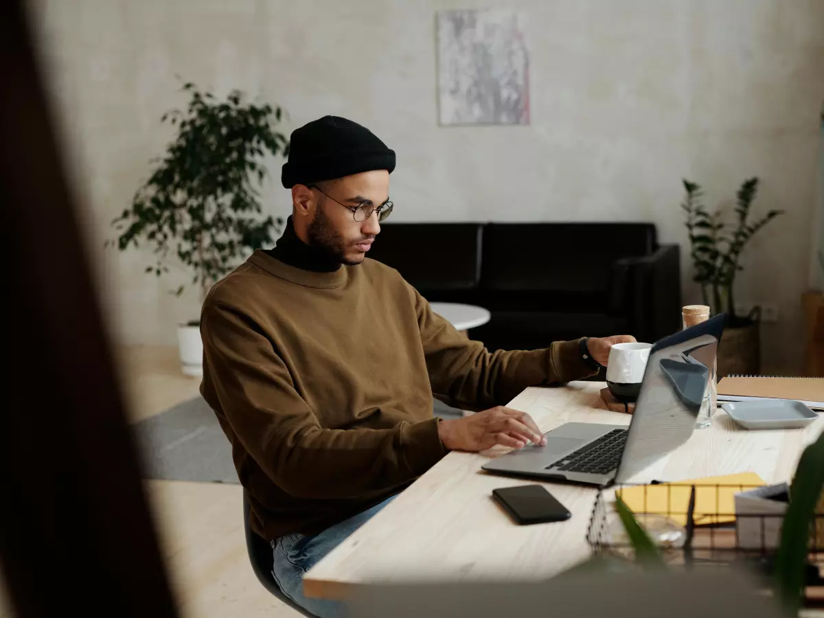 A person sitting at a desk using a Lenovo Yoga Slim 7i laptop.