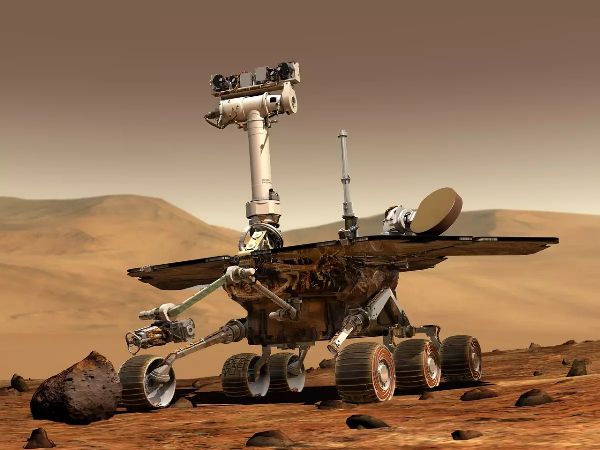 A robotic rover with solar panels and wheels on a desolate red surface.