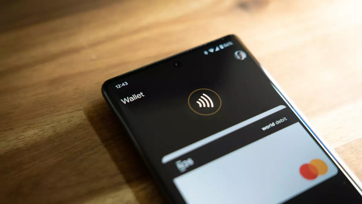 A close-up of a smartphone screen displaying the Google Wallet app. The phone is lying on a wooden surface, showcasing a dark background.