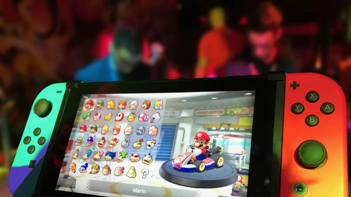 A close-up shot of a Nintendo Switch console with joy-cons, displaying a bright and colorful video game.