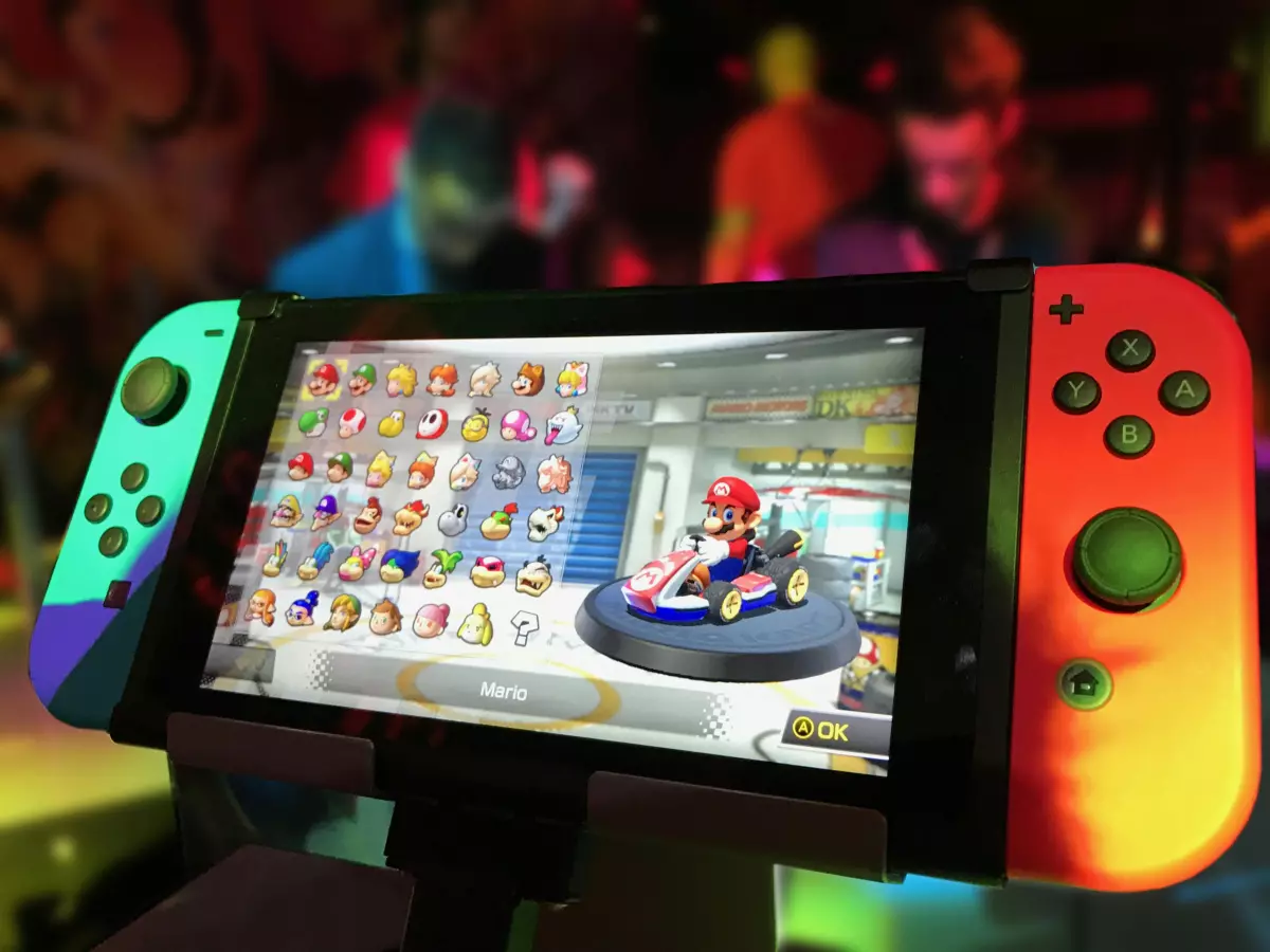 A close-up shot of a Nintendo Switch console with joy-cons, displaying a bright and colorful video game.