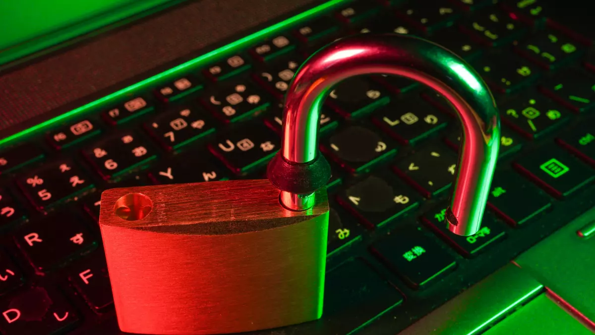 A padlock sits on a laptop keyboard with red and green lighting.