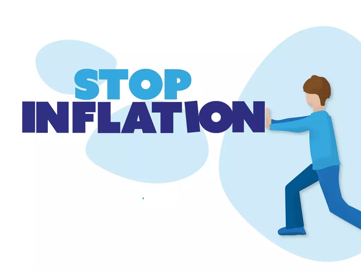 A cartoon illustration of a man pushing against the word 'STOP INFLATION' in blue text, symbolizing the fight against inflation.